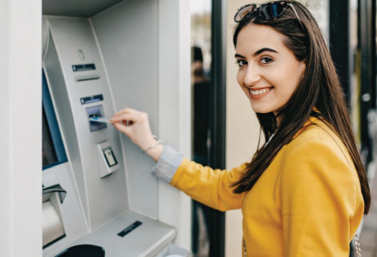 A girl uses an ATM machine