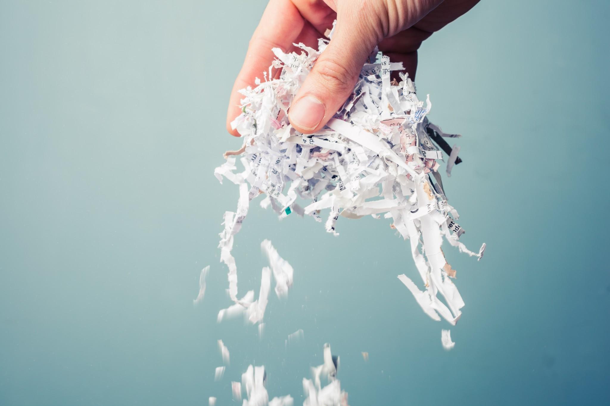 A hand holds shredded paper