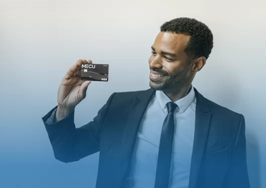Man holding a MECU Visa Rewards Card.