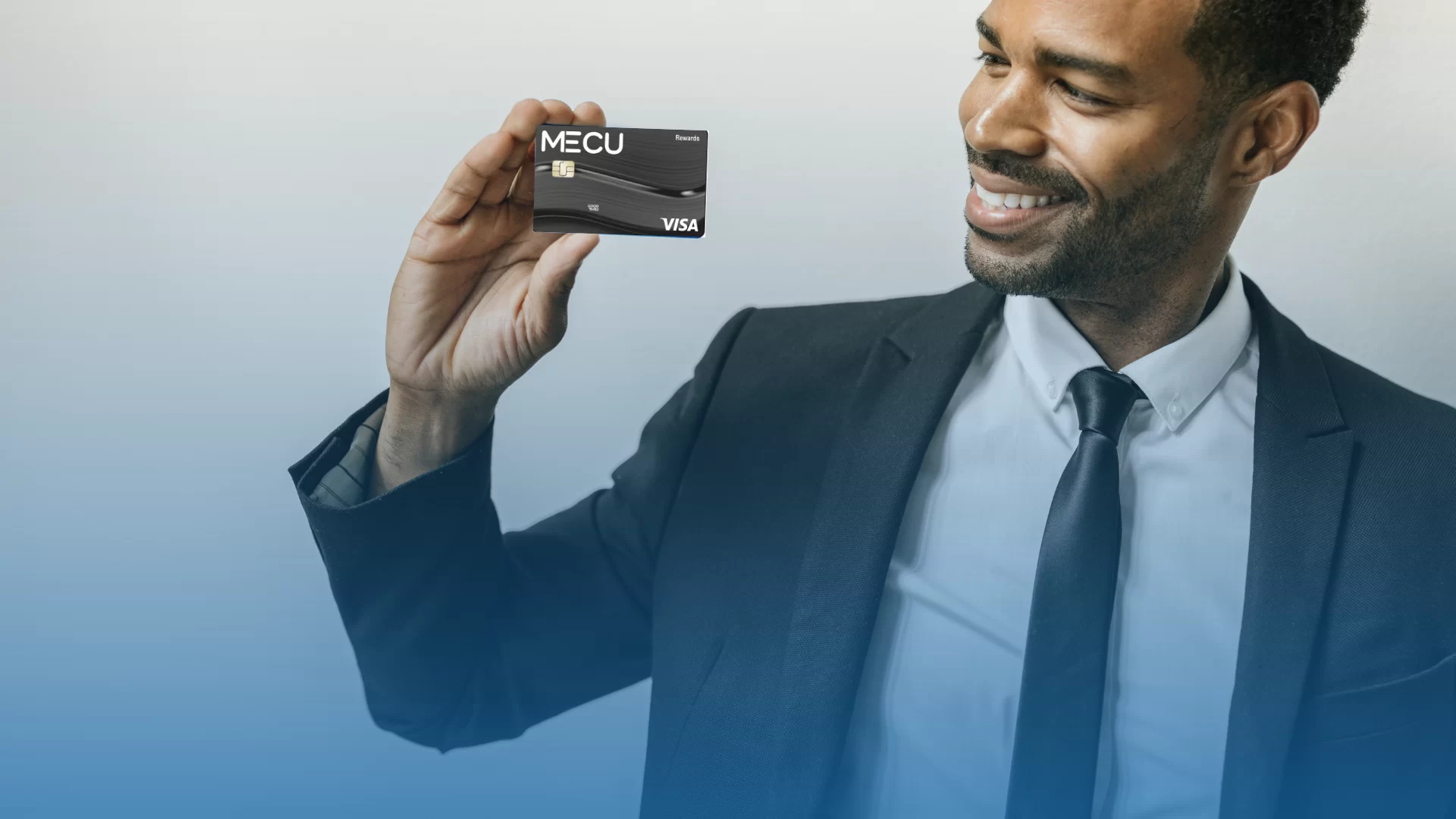 Man holding a MECU Visa Rewards Card.