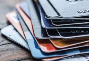 Stack of colorful credit cards on a wooden table.