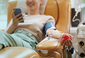 A young lady relaxes in a chair while giving blood.