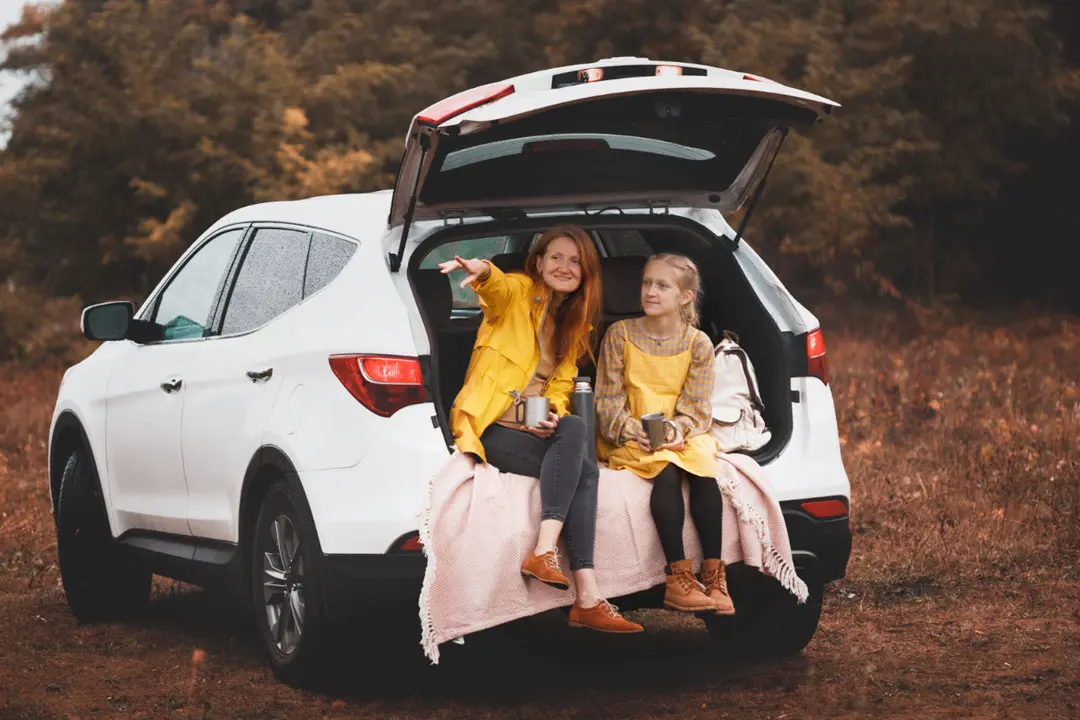 A mother and daughter enjoy sitting in the back of their new vehicle