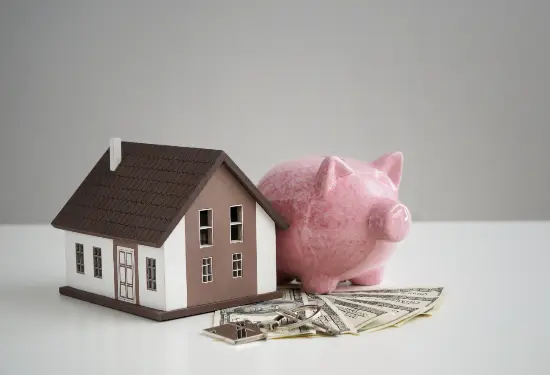 A toy house is next to a piggy bank