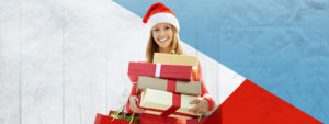 Woman holding gifts wearing a red Santa Hat