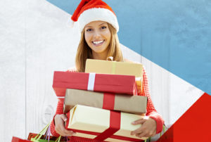 Young lady in a Santa hat holding gifts