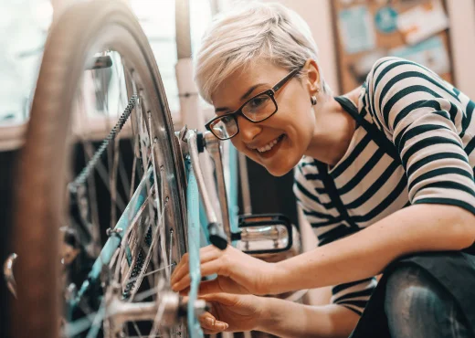female bicycle shop owner smiling as she works on a bike rim