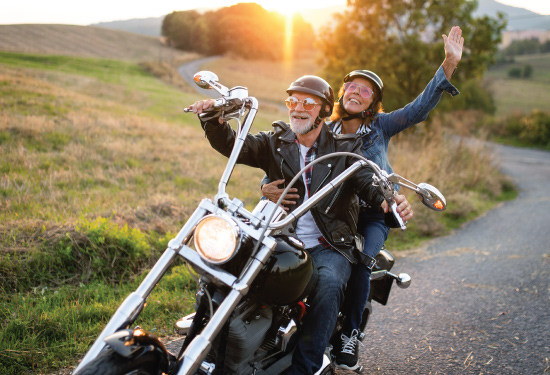 Adult couple enjoying their motorcycle on a winding road
