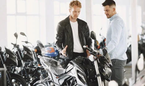 young adult male and salesman discussing purchasing a motorcycle