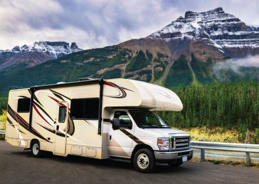 family RV stopped along picturesque snowy mountain