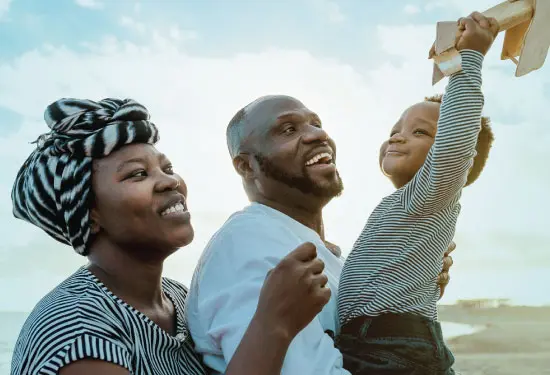 A family has fun with their young son on the beach.