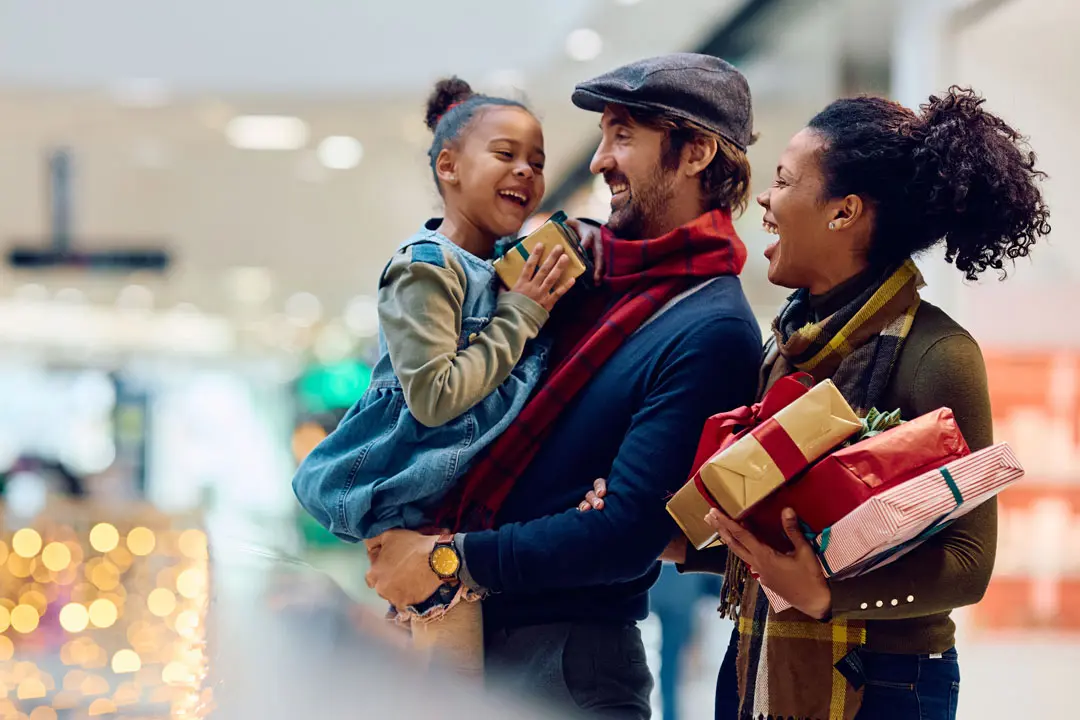 A couple shops for gifts with their young daughter