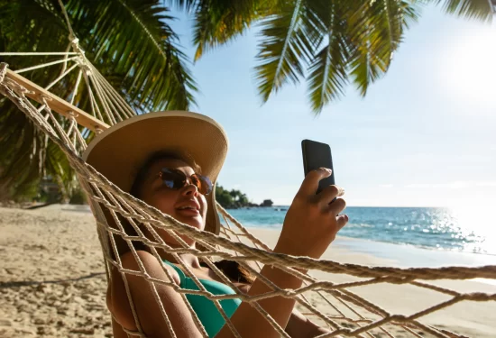 Woman relaxes in a hammock on the beach.