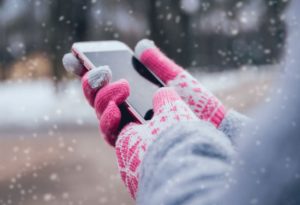 Girl using her smart phone in winter